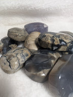 Smooth volcano agate palmstone from Syn's Crystal Co, showcasing rich orange and brown hues with natural banding patterns.
