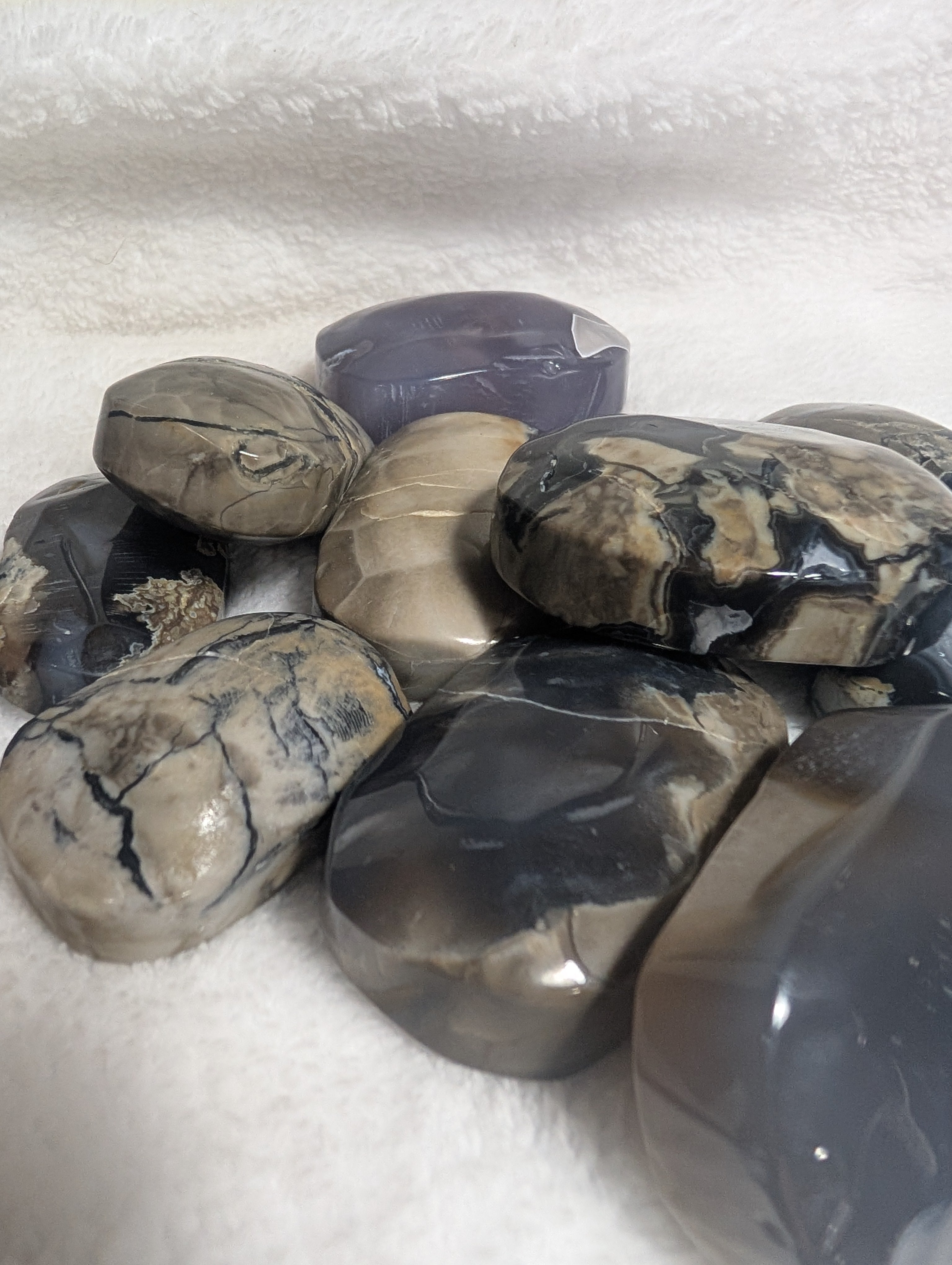 Smooth volcano agate palmstone from Syn's Crystal Co, showcasing rich orange and brown hues with natural banding patterns.