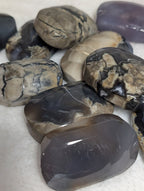 Syn's Crystal Co Volcano Agate palmstone showing vibrant orange and brown banding, smooth polished gemstone for meditation and healing.