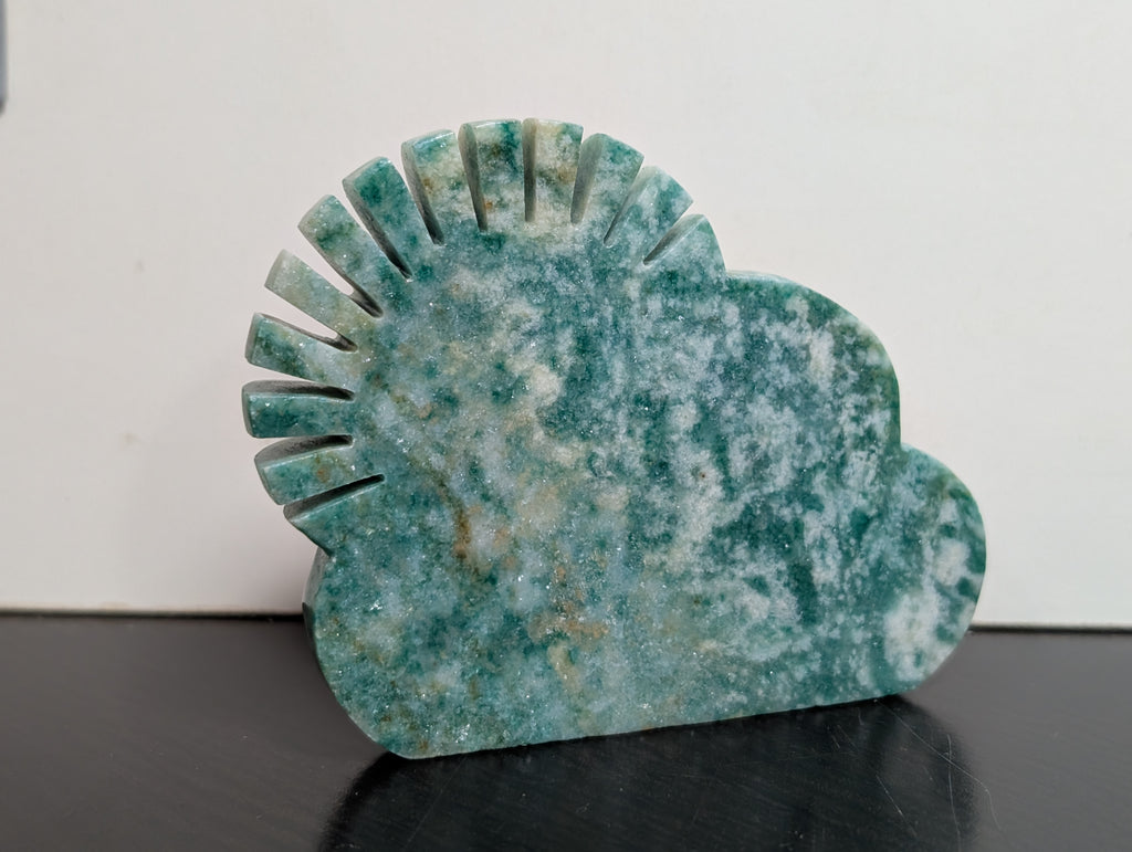 Green Aventurine sun and cloud carving by Syn's Crystal Co, featuring detailed green stone shapes of the sun and clouds.