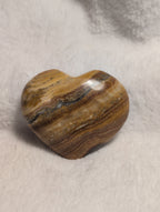 Smooth Bumblebee Calcite heart-shaped crystal from Syn's Crystal Co with vibrant yellow and black banding on a white background.