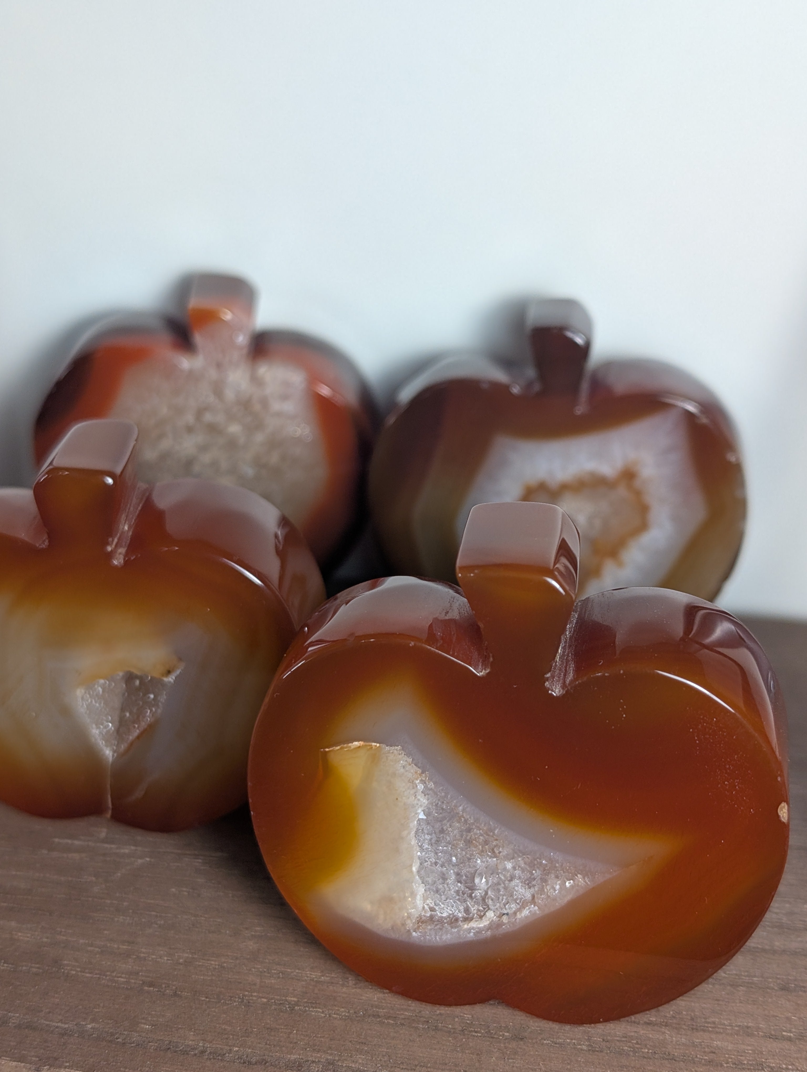 Hand-carved Carnelian crystal apple sculpture by Syn's Crystal Co, showcasing vibrant orange-red stone for creativity and abundance.