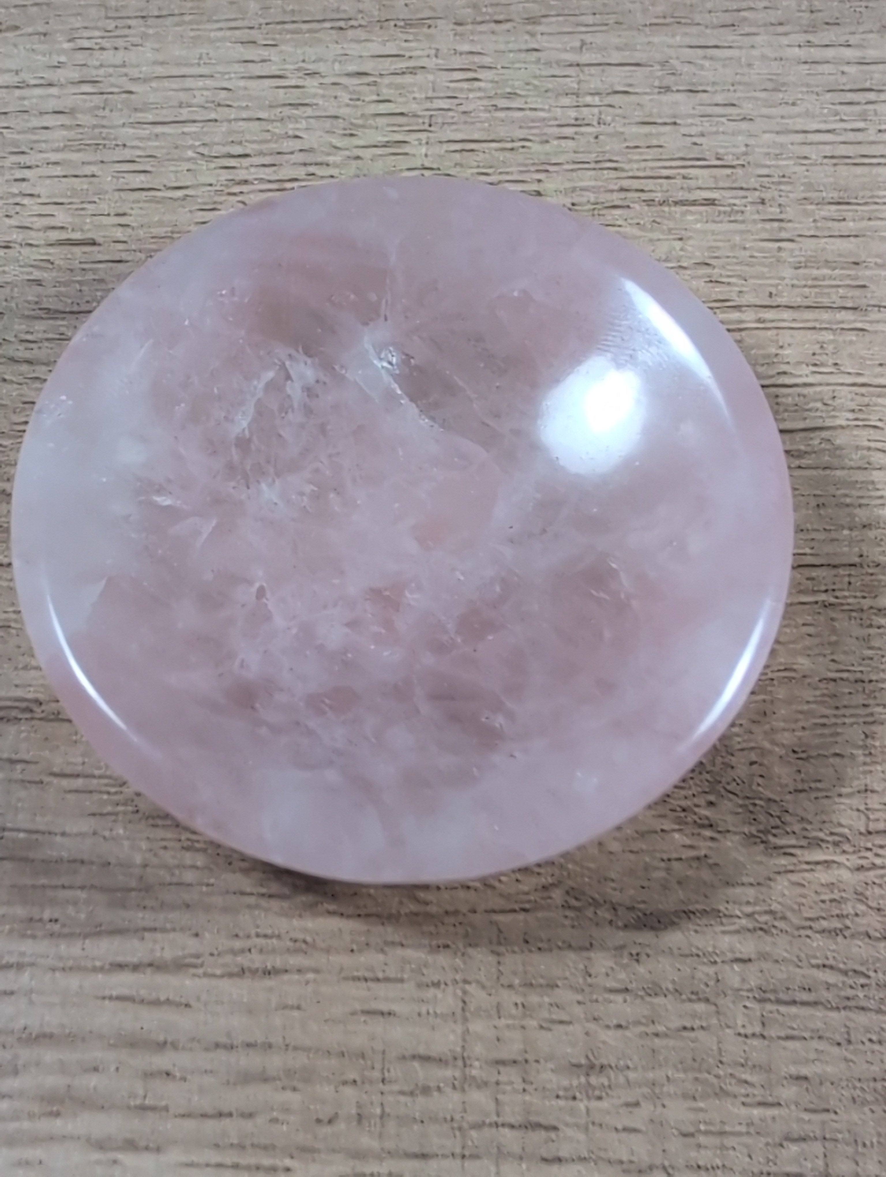 Round rose quartz bowl from Syn's Crystal Co with smooth, polished pink stone surface and a rounded shape.