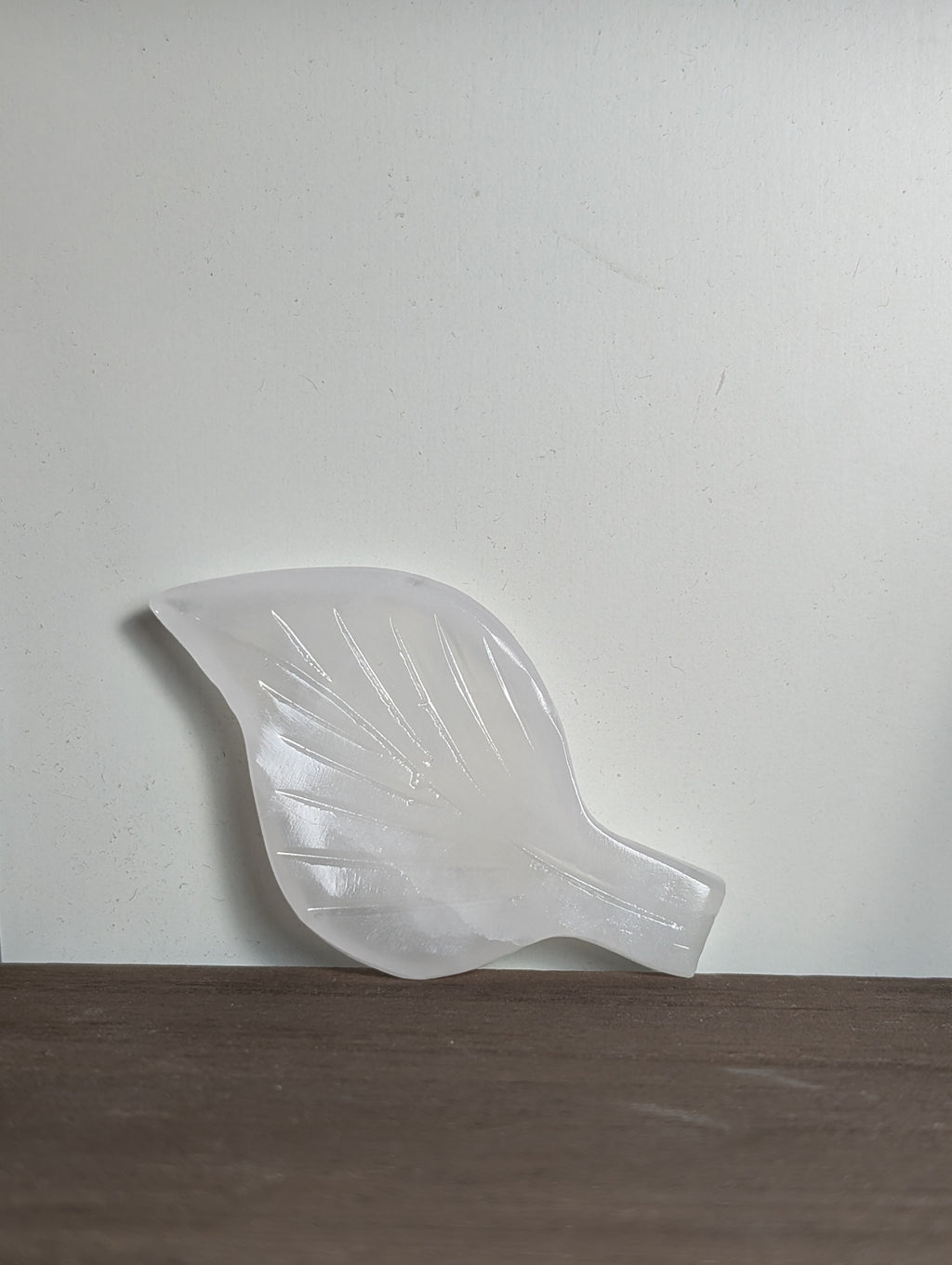 White calcite leaf carving by Syn's Crystal Co, showcasing intricate details and smooth texture in a natural, elegant design.