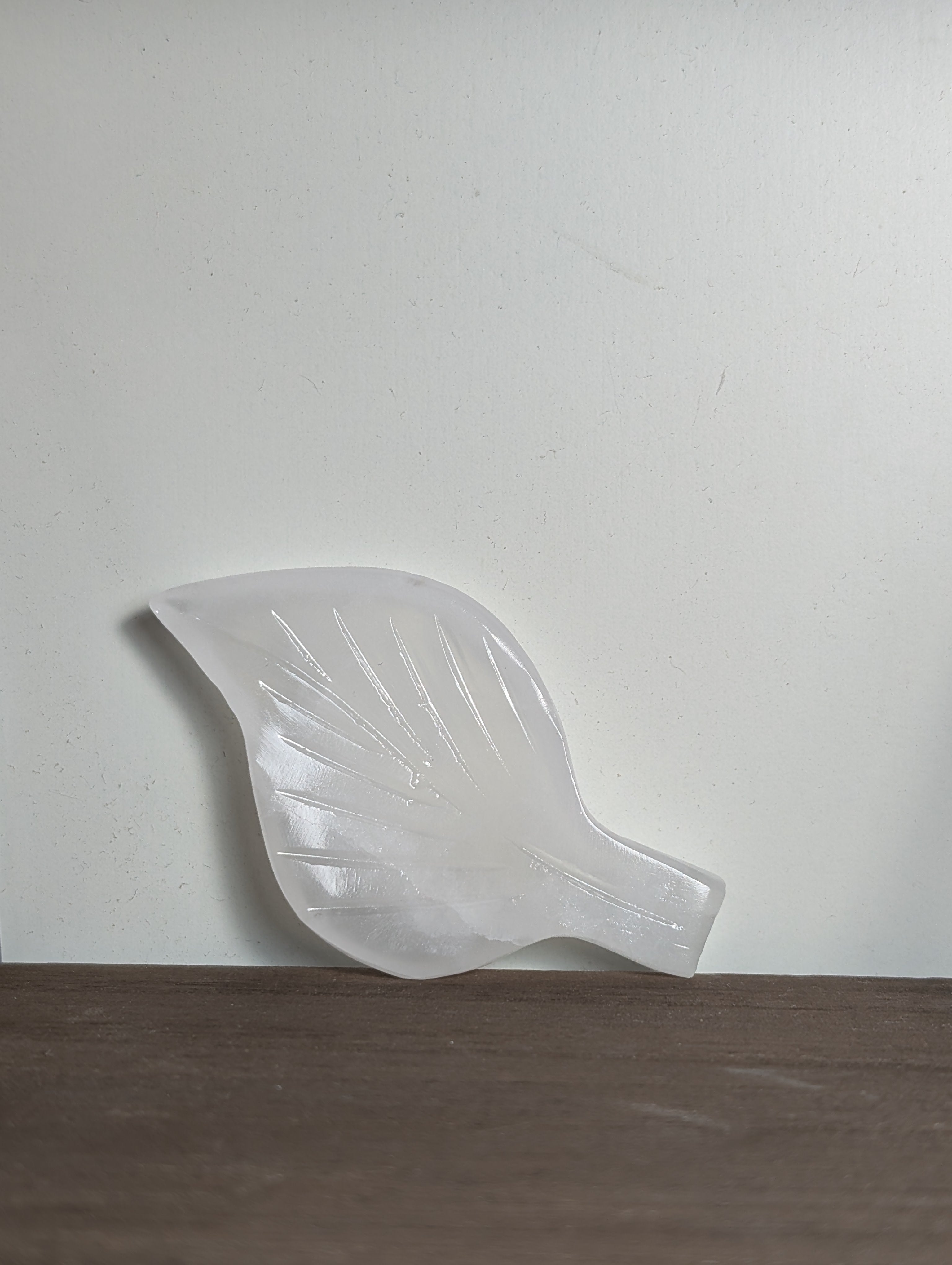 White calcite leaf carving by Syn's Crystal Co, showcasing intricate details and smooth texture in a natural, elegant design.