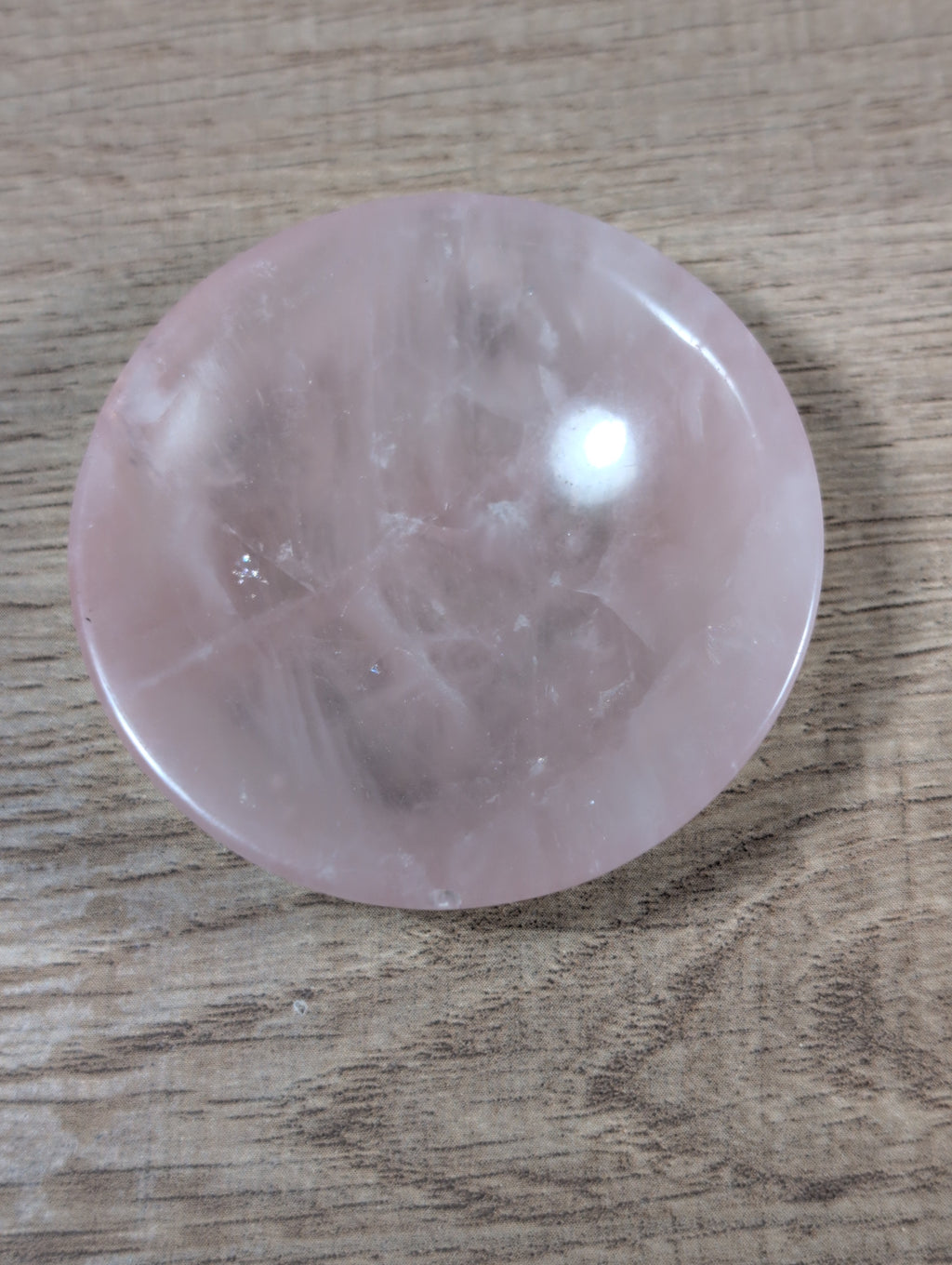 Round rose quartz bowl by Syn's Crystal Co, showcasing smooth pink gemstone with a polished, glossy surface.