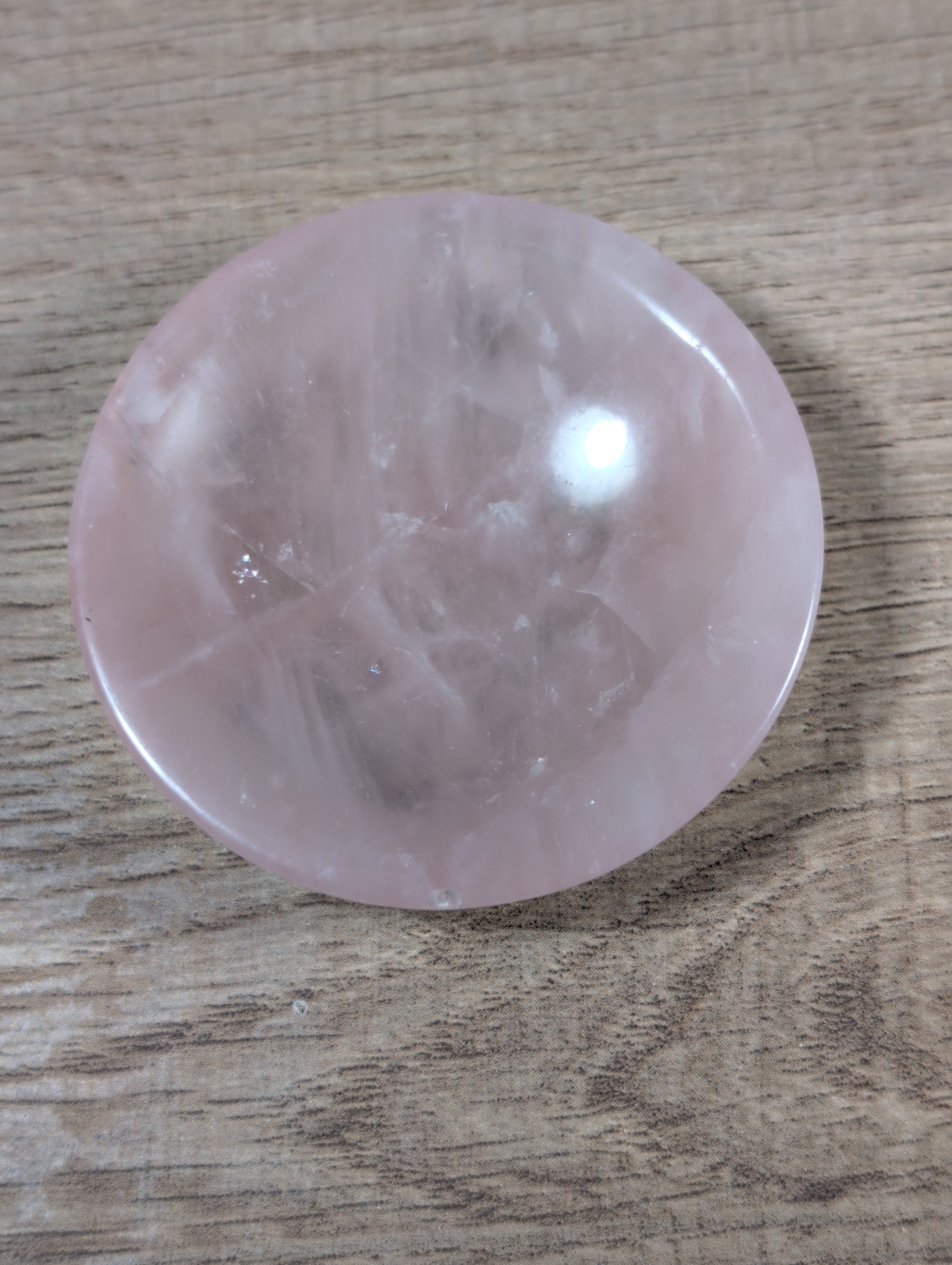 Round rose quartz bowl by Syn's Crystal Co, showcasing smooth pink gemstone with a polished, glossy surface.