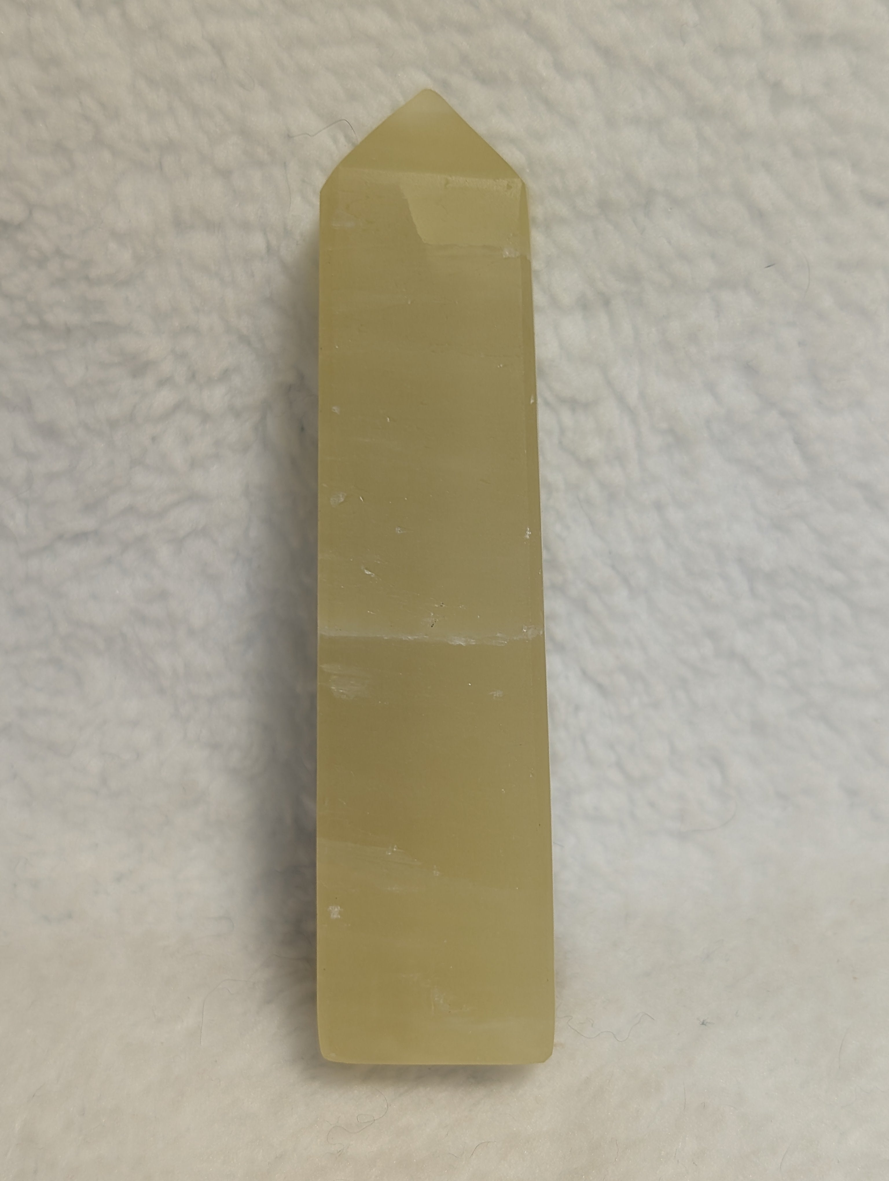 Lemon Calcite Tower from Syn's Crystal Co, showcasing a vibrant yellow mineral crystal with natural striations and smooth polished surface.