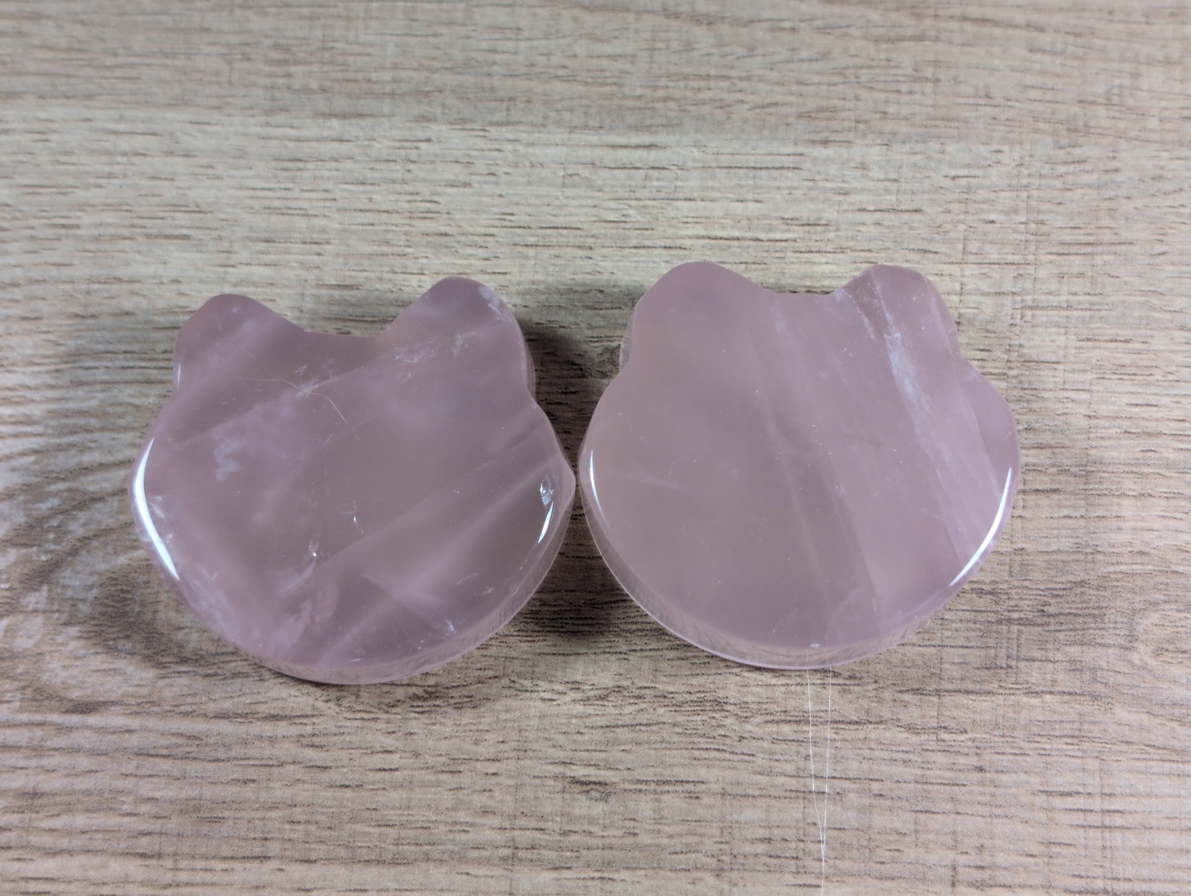 Rose quartz bowl shaped like a teddy bear head, featuring smooth pink crystal with translucent and polished surfaces.