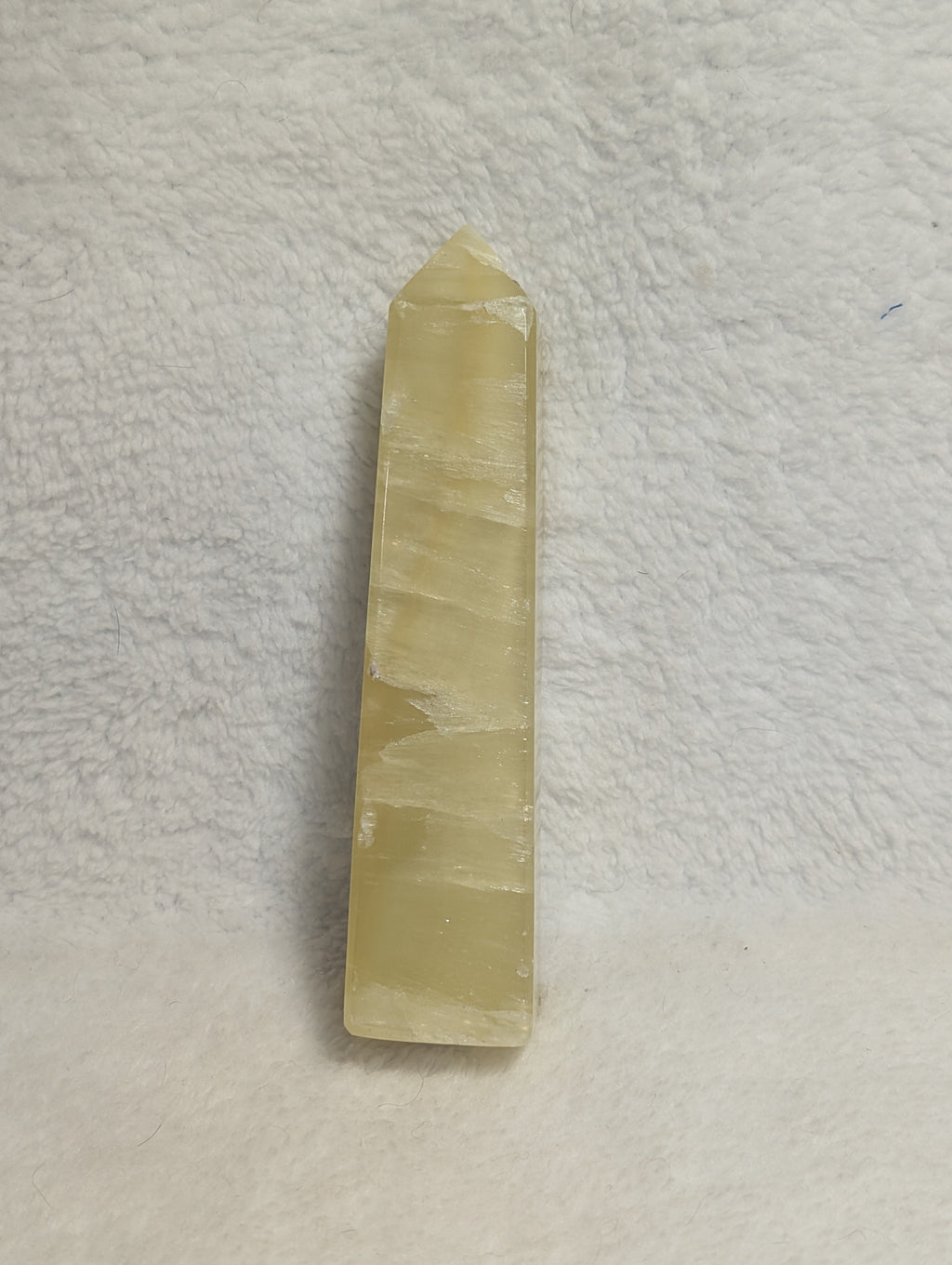 Lemon Calcite tower crystal for Solar Plexus Chakra, showing a yellow calcite point with natural striations and a polished finish.
