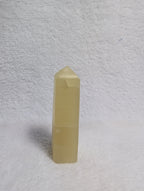 Lemon Calcite Tower from Syn's Crystal Co featuring a vibrant yellow crystal point on a natural mineral base.