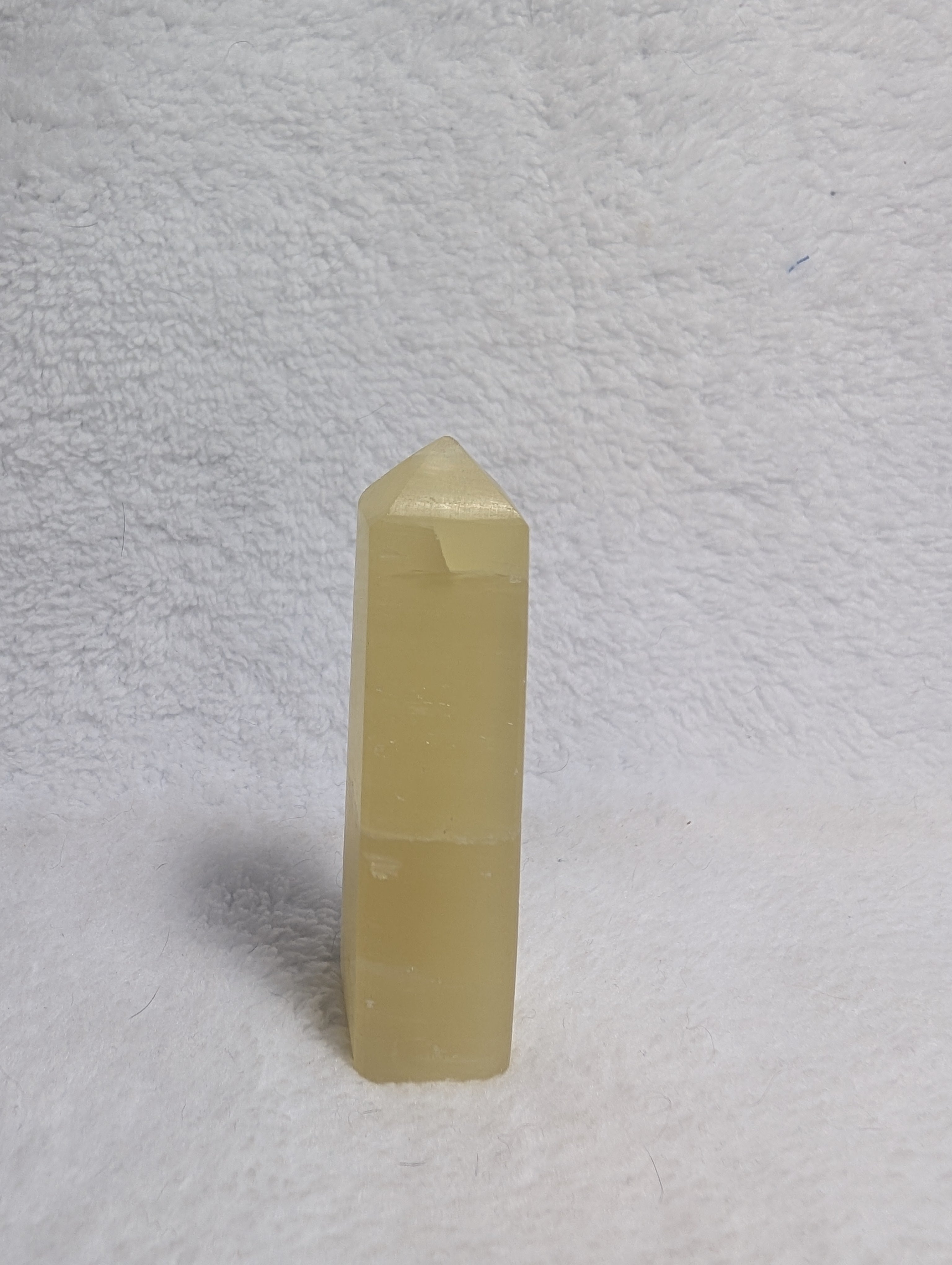 Lemon Calcite Tower from Syn's Crystal Co featuring a vibrant yellow crystal point on a natural mineral base.