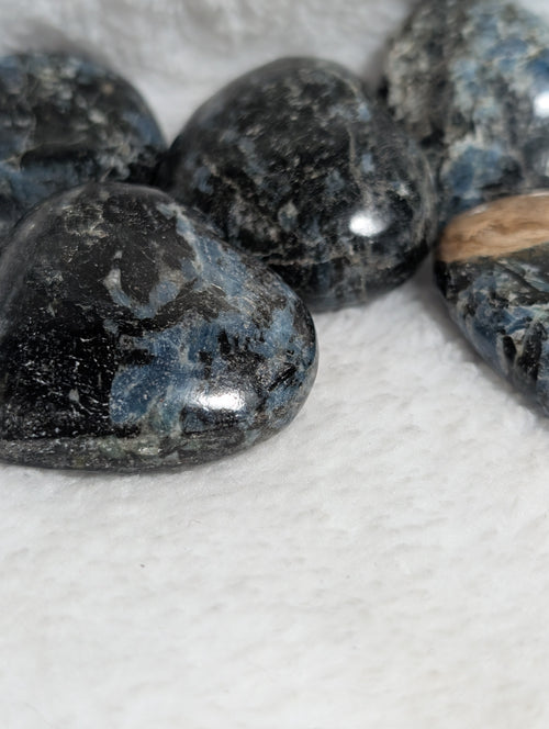 Blue Apatite and black tourmaline heart palm stones from Syn's Crystal Co, featuring polished, smooth gemstone hearts.
