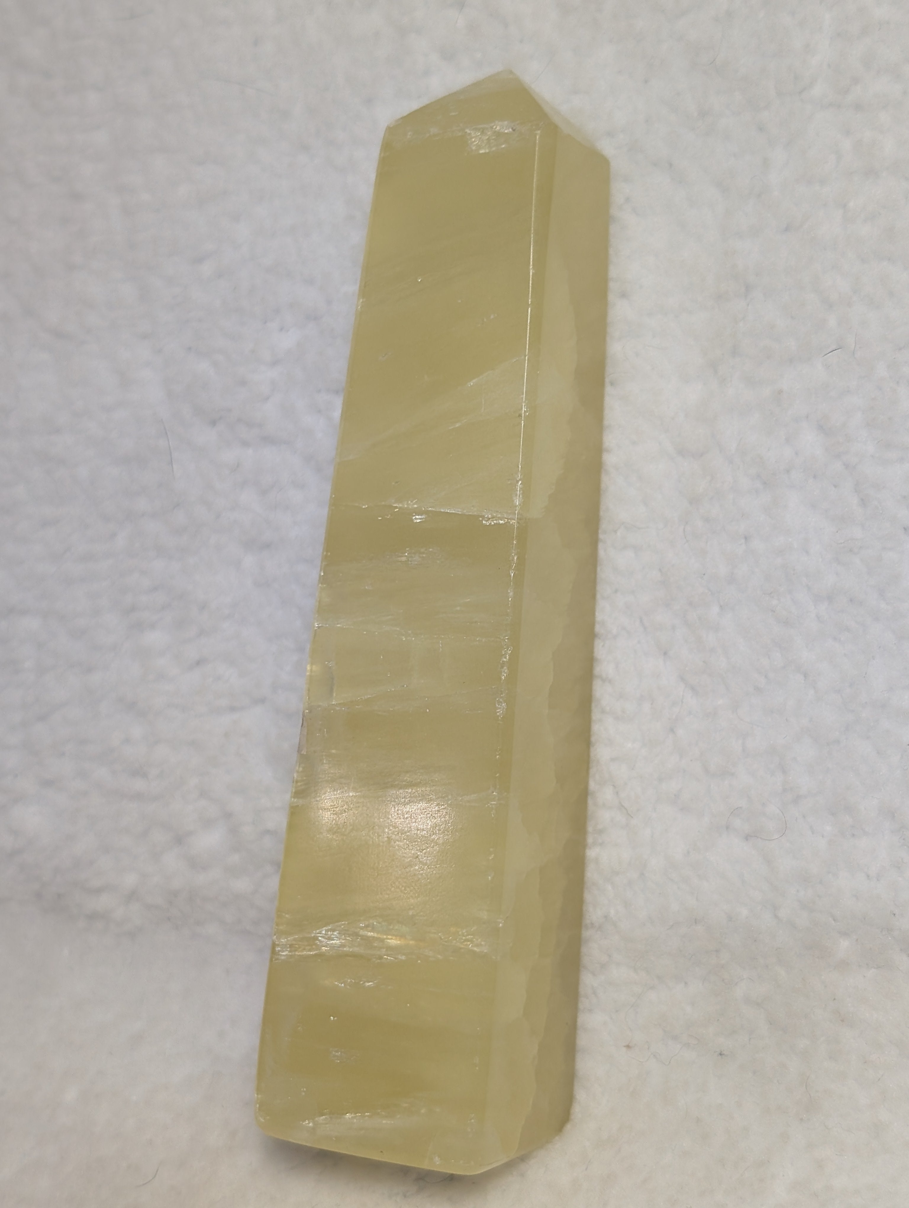 Lemon Calcite Tower from Syn's Crystal Co, showcasing a vibrant yellow crystal point with natural mineral textures.