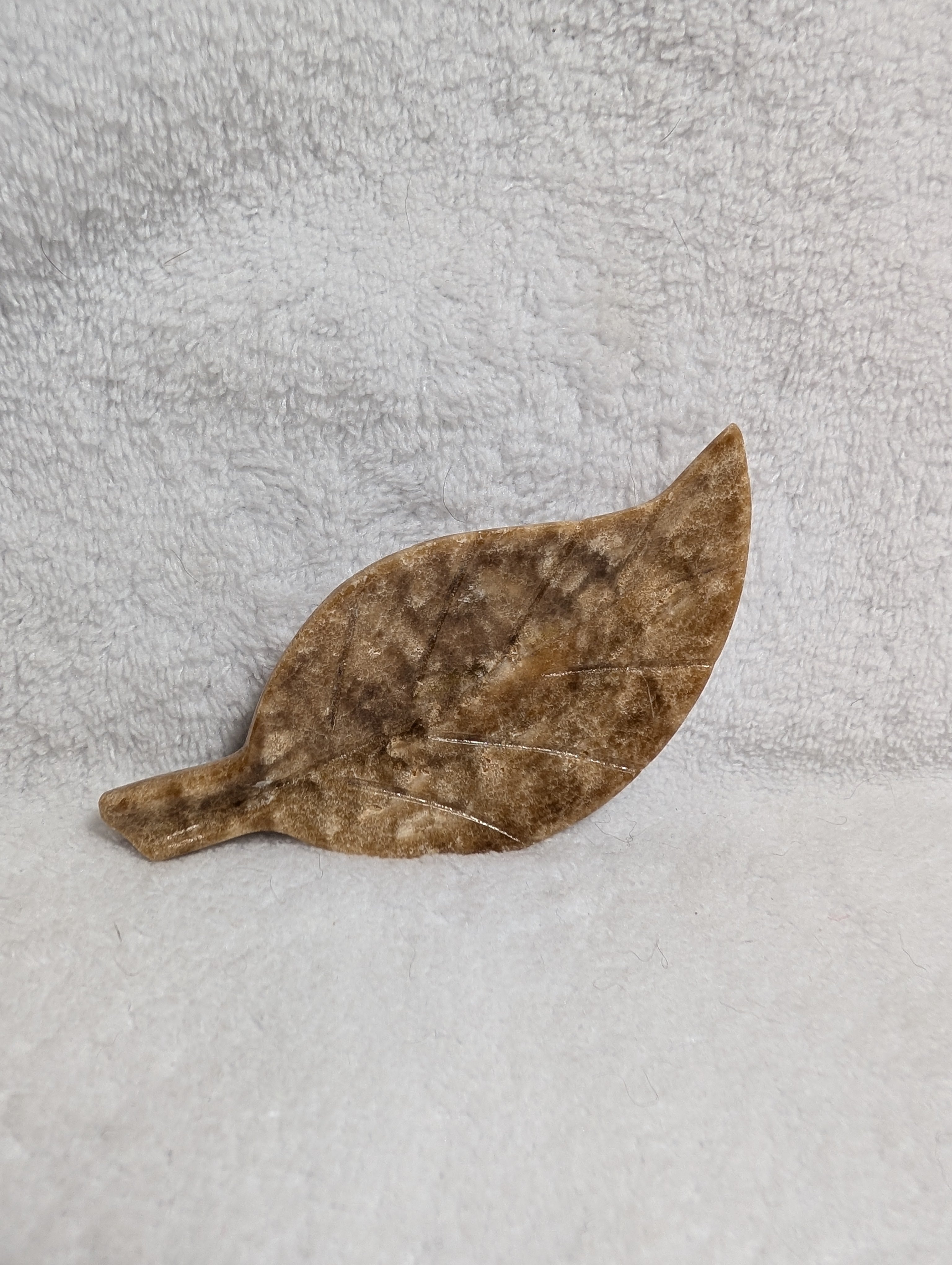 Chocolate Calcite Leaf crystal from Syn's Crystal Co, showing a polished brown and green gemstone shaped like a leaf.