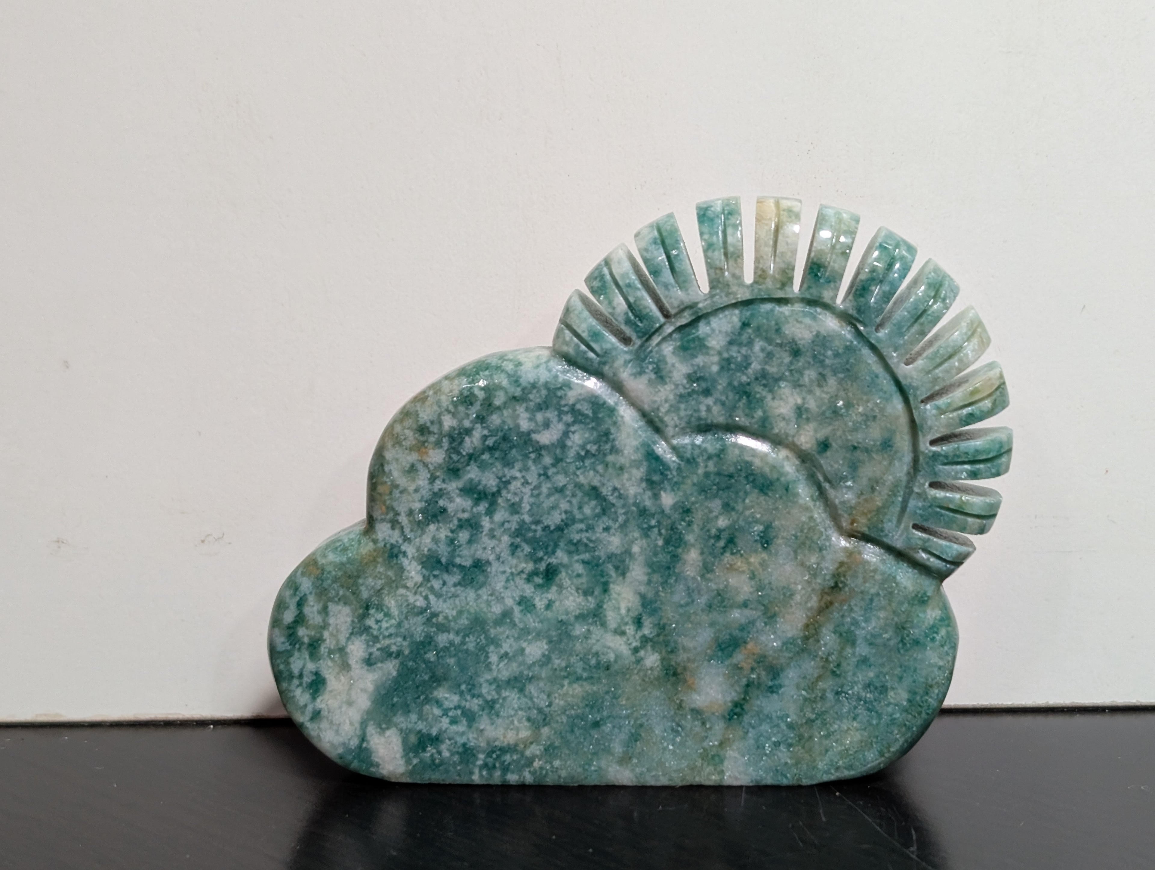 Green aventurine sun and cloud carving by Syn's Crystal Co, detailed stone sculpture with vibrant green hues and intricate design.