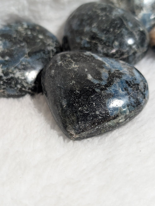 Blue Apatite and Black Tourmaline heart palm stones from Syn's Crystal Co, showing smooth, polished crystals with vibrant blue and dark black colors.