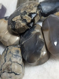 Syn's Crystal Co Volcano Agate palmstone featuring vibrant orange and red swirls, smooth polished surface for meditation and healing.