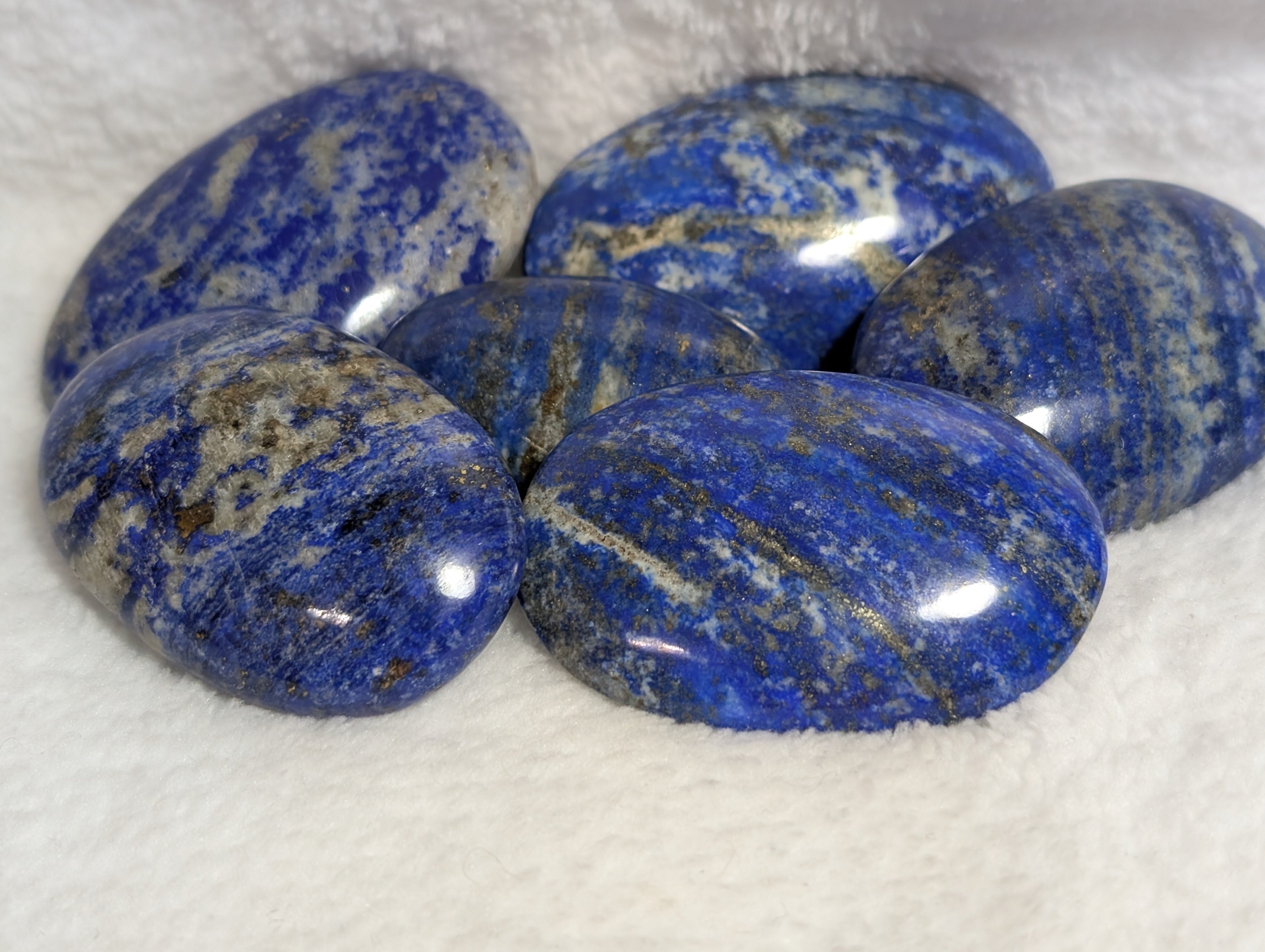 Lapis Lazuli palmstone from Syn's Crystal Co, polished blue stone with gold and white veining, smooth and rounded for meditation.