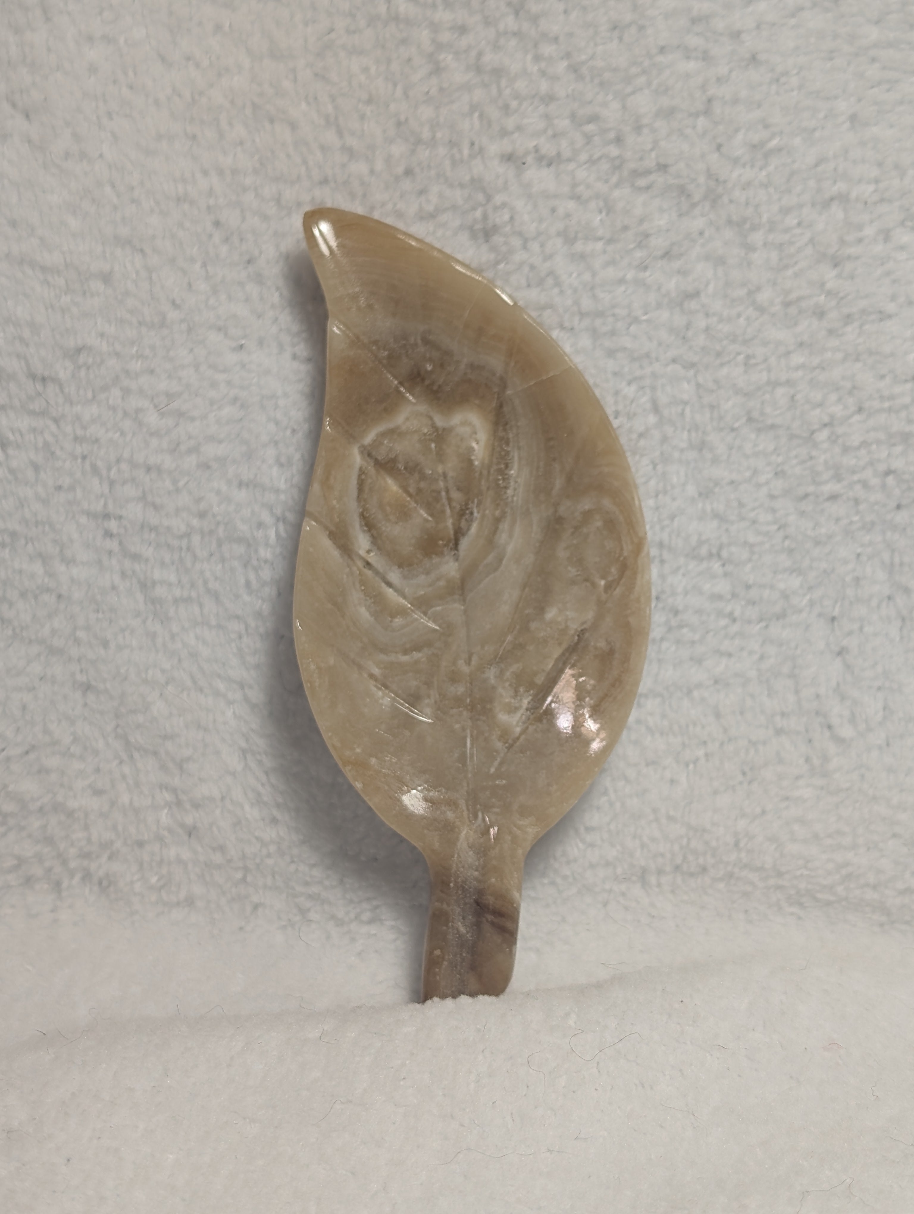 Chocolate Calcite Leaf carving by Syn's Crystal Co showing a detailed, polished stone with leaf-shaped design and rich brown color.