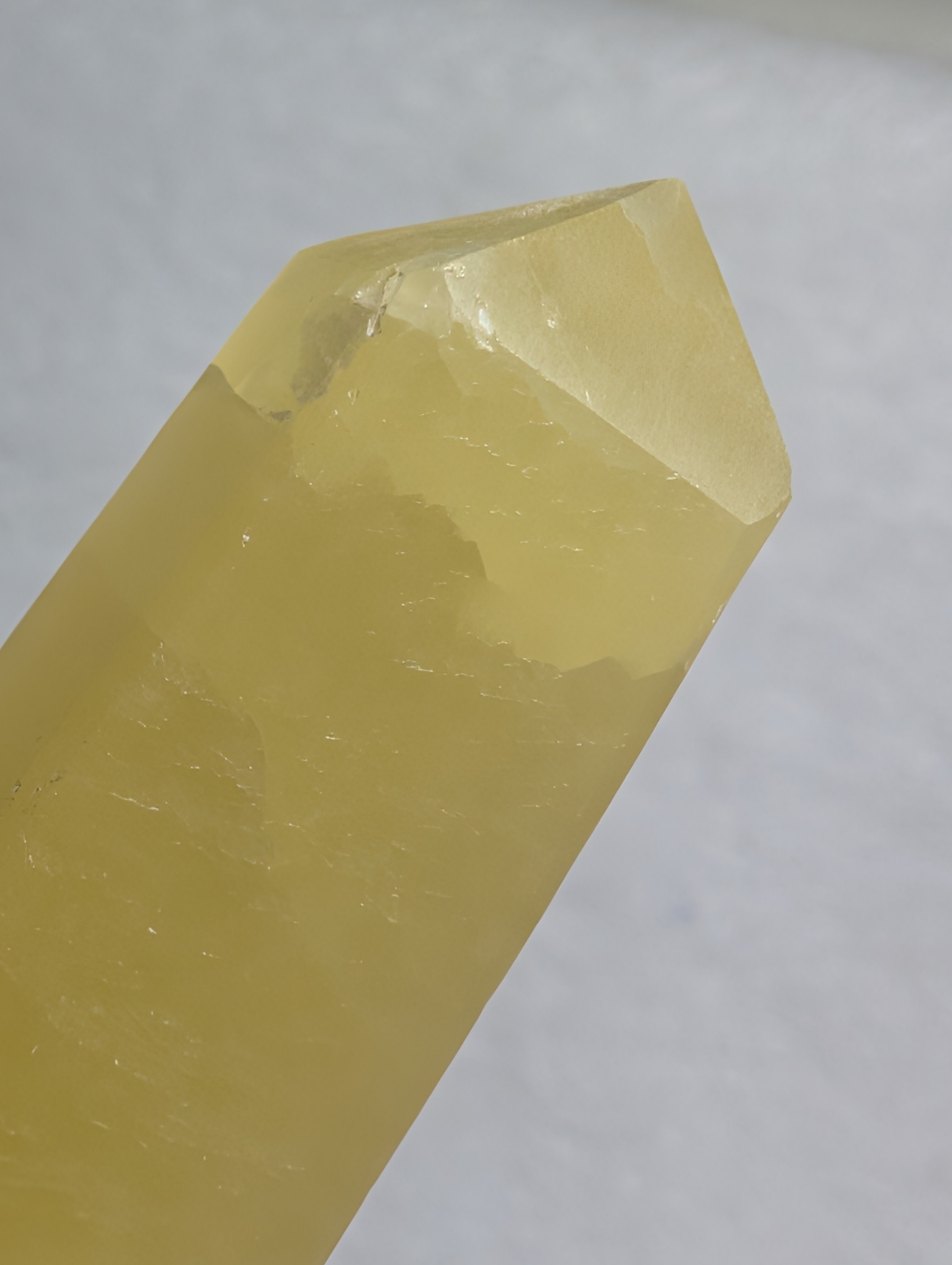 Lemon Calcite tower crystal from Syn's Crystal Co, showing a vibrant yellow mineral with natural crystal formations.