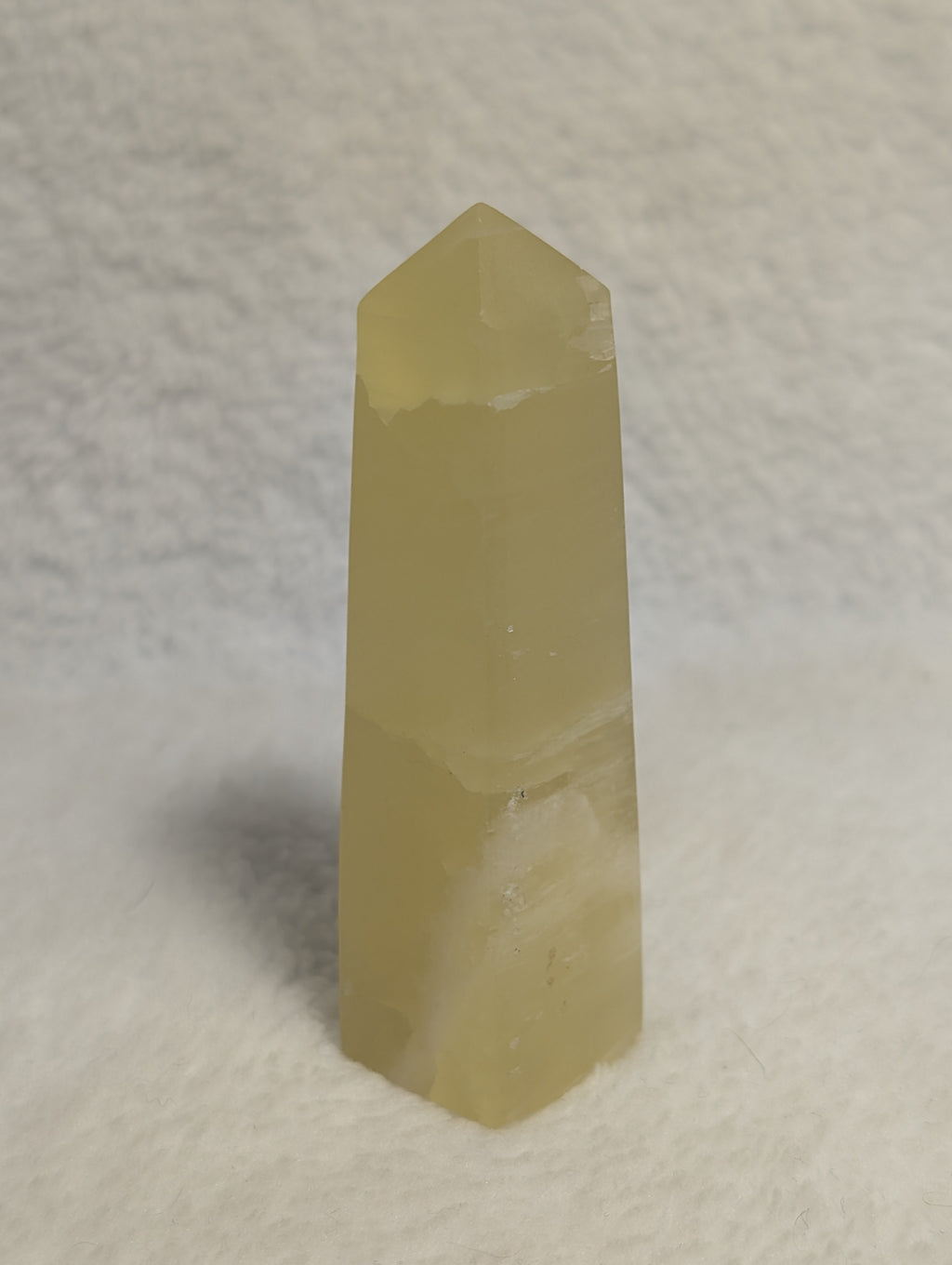 Lemon Calcite Tower from Syn's Crystal Co, showcasing a vibrant yellow crystal with natural geometric facets.