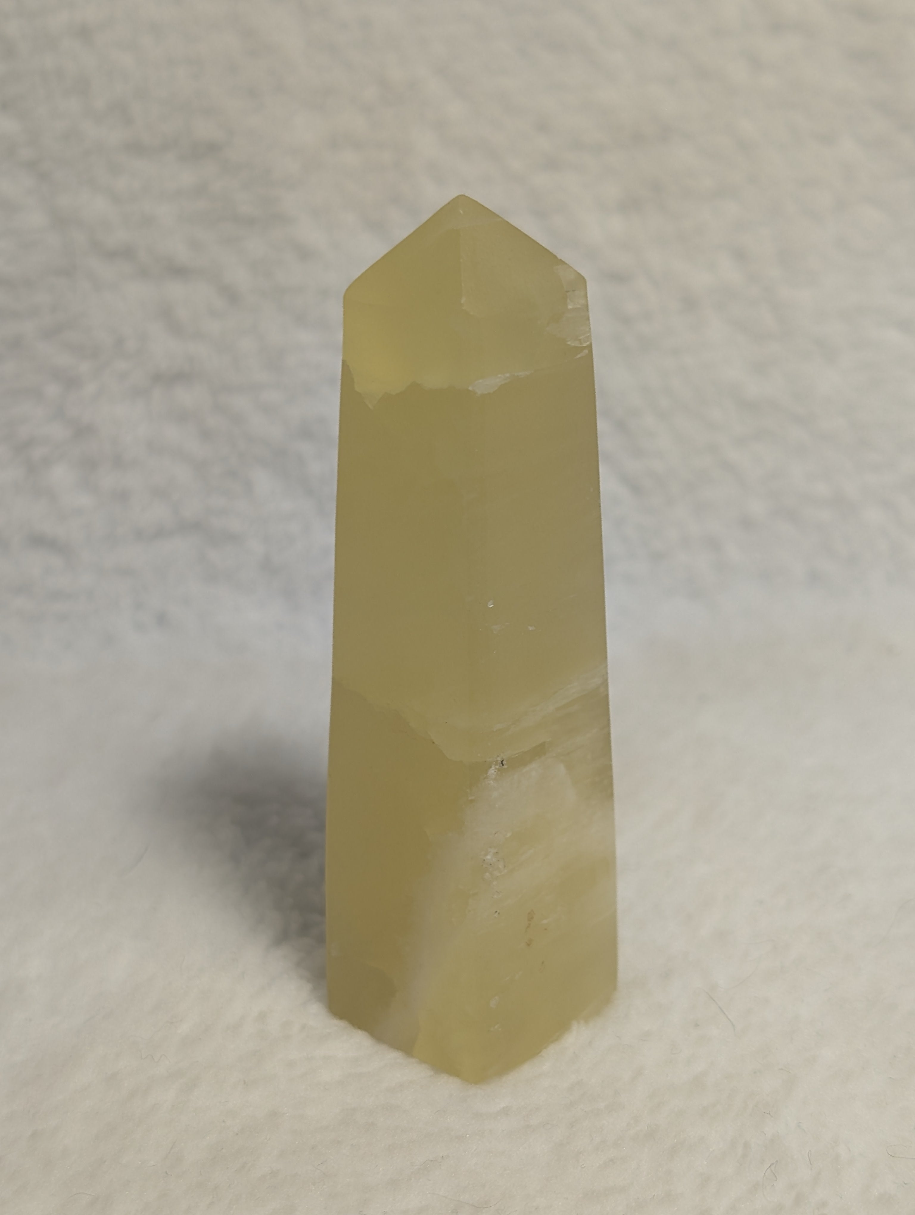 Lemon Calcite Tower from Syn's Crystal Co, showcasing a vibrant yellow crystal with natural geometric facets.
