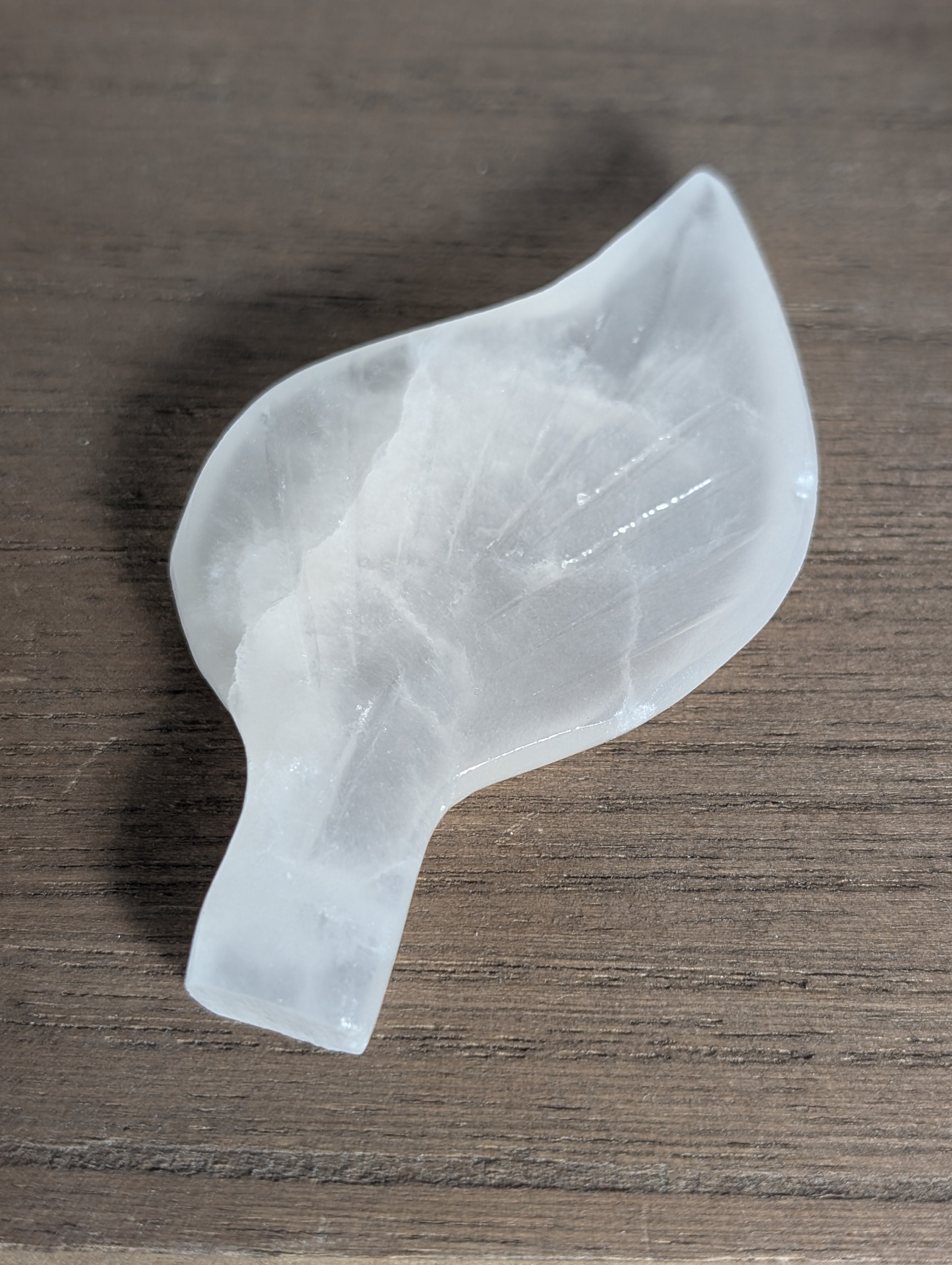 Silky white calcite leaf carving by Syn's Crystal Co, featuring intricate leaf details and smooth polished surface.